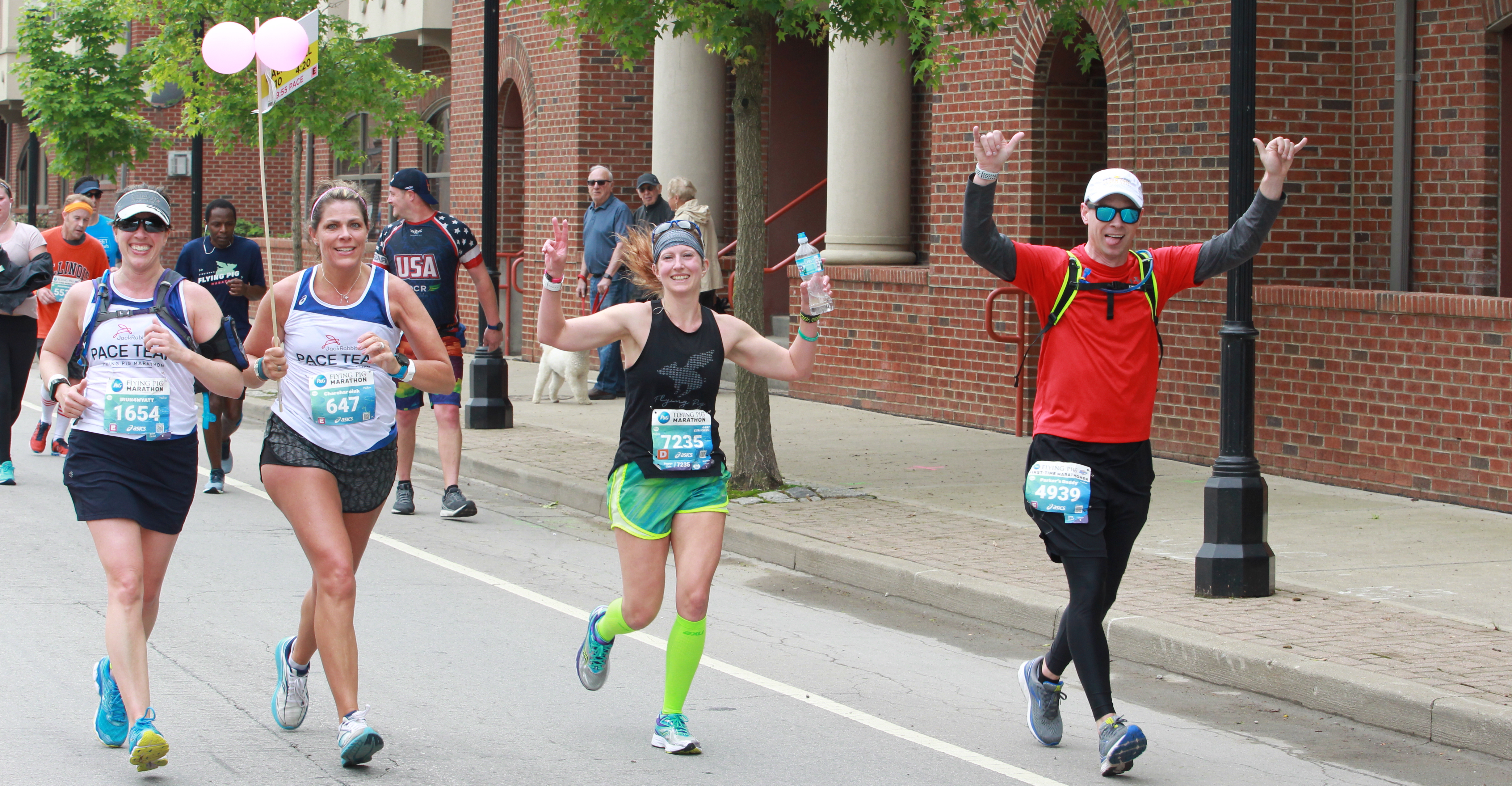 2 members of the pace team running with two runners on the full marathon course