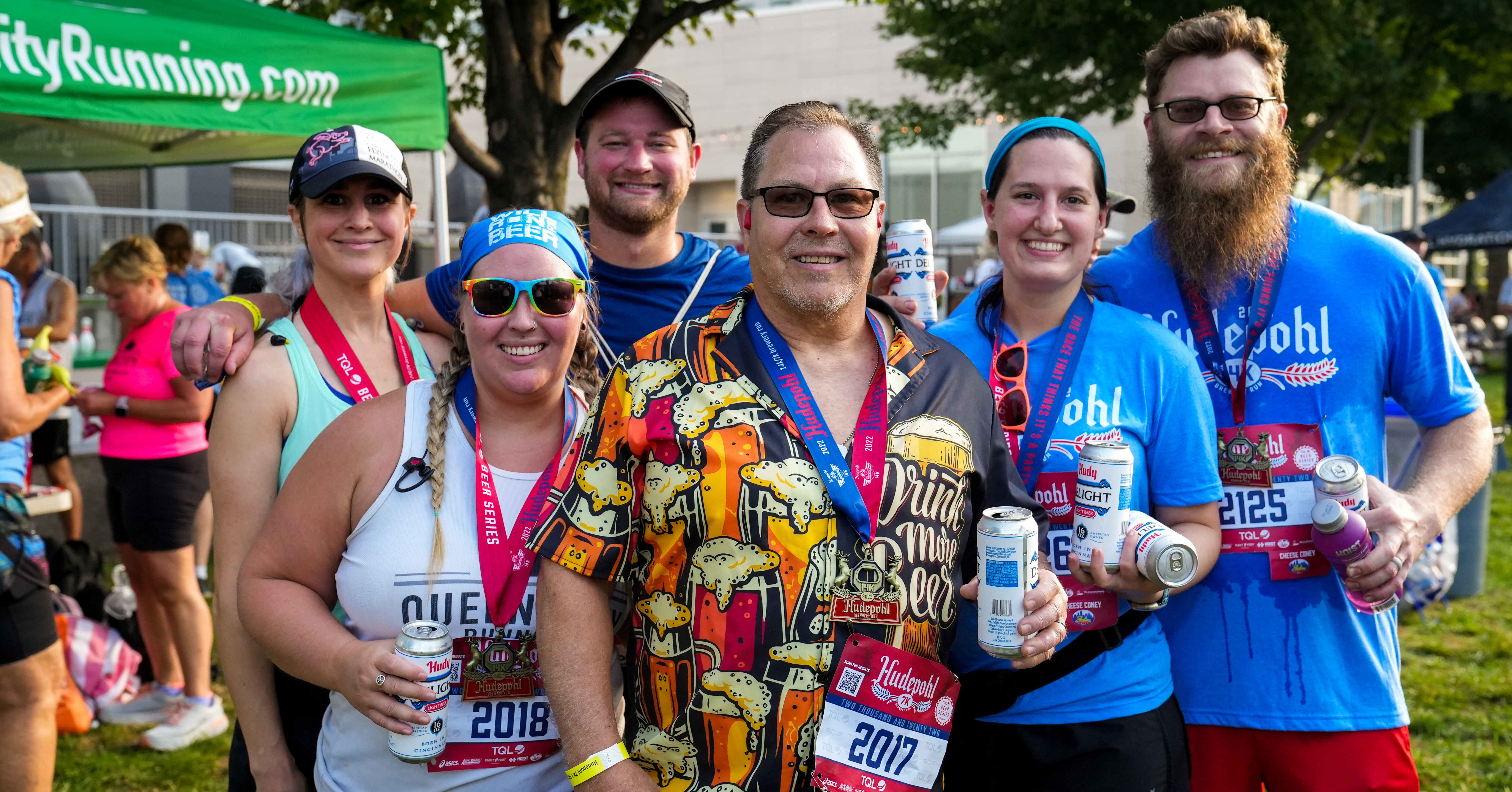 group of participants smiling and holding cans of beer